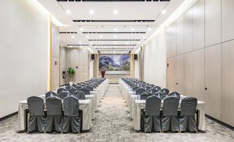 a large conference room with rows of chairs arranged in a semicircle , ready for a meeting at Atour Hotel