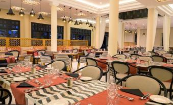 a large , well - decorated dining room with tables and chairs arranged for a group of people to enjoy a meal together at Sol Oasis Marrakech - All Inclusive