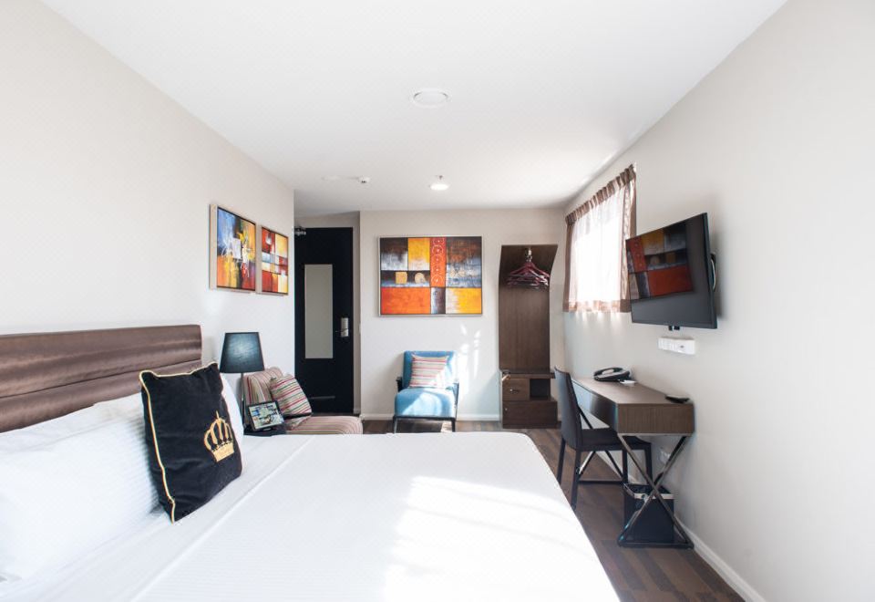 a modern hotel room with a bed , desk , and tv , along with a large window and artwork on the walls at 57Hotel