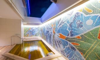 a long , narrow room with a skylight above it and a colorful mural on the wall at Loisir Hotel Naha