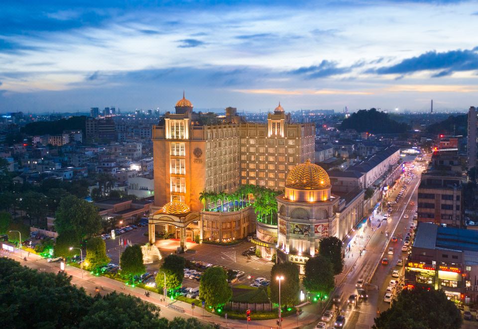 a large , ornate building with multiple towers and a green dome is surrounded by a busy city street at Golden Hotel