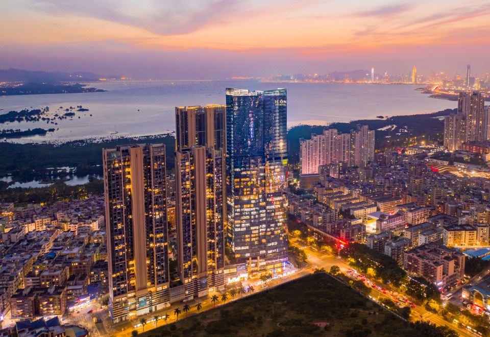 A city's illuminated skyline at night with buildings on both sides at ICON LAB Hotel Shenzhen Futian