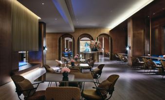 There is an open concept living area with tables and chairs in the middle at Blossom House Shanghai On The Bund