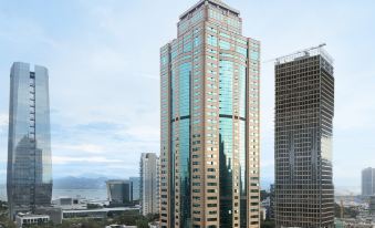 There is a large building surrounded by tall skyscrapers and other buildings on both sides at Insio Hotel (Shenzhen Shekou Maritime World)