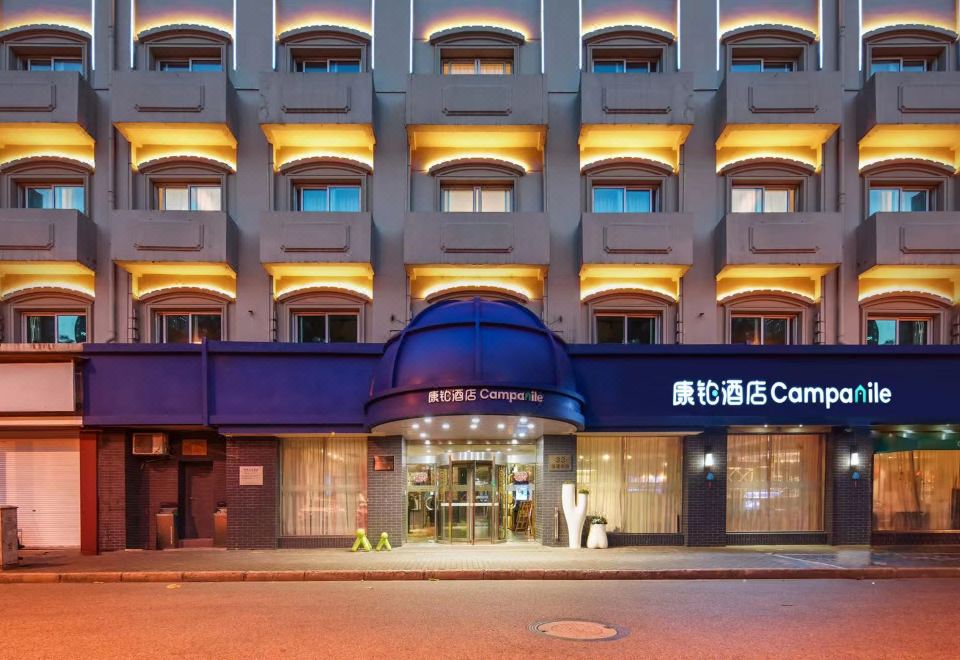 At night, a time-lapse video captures the front entrance of a hotel with an illuminated sign at Campanile Hotel (Shanghai The Bund)