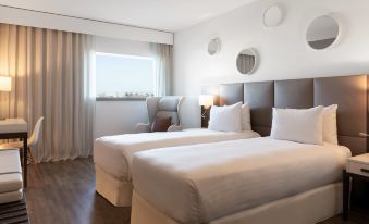 a hotel room with two beds , one on the left and one on the right side of the room at AC Hotel Paris le Bourget Airport