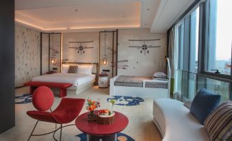 A spacious apartment-style room is furnished with a bed, table, and chairs at Yindu Hotel