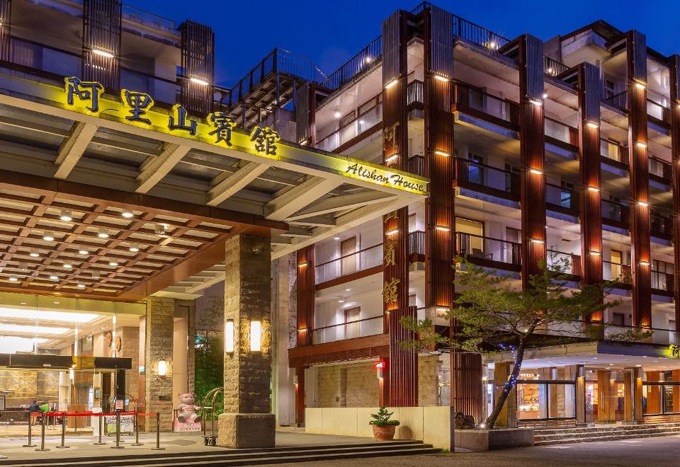 a hotel entrance with a large sign above it , indicating the name of the hotel at Alishan House