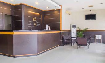 a modern reception area with a large window , a black and gold counter , and several chairs arranged around it at Alpha Inn