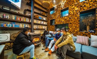 A group of people is sitting in a living room with their feet up on one side at Yangshuo Sudder Street Guesthouse