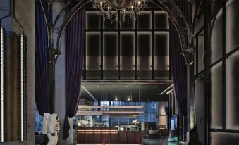 The lobby features two large windows and an arched doorway that leads to another room at Wanda Moments