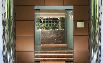 a modern elevator with a marble wall and wooden steps leading up to it , illuminated by overhead lights at Bianca Relais