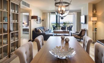 a modern living room with a dining table , chairs , and a large window overlooking the ocean at Radisson Blu Resort, Gran Canaria