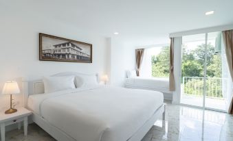 A bedroom with two beds and an attached bathroom at B2 Phuket Premier Hotel