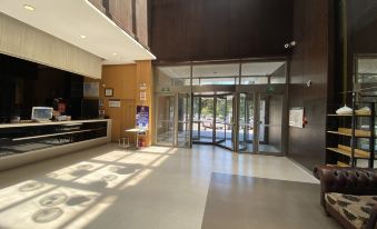 The modern building features a lobby and entrance with wood paneled walls on both sides at Jinjiang Inn(Beijing Tongzhou Beiyuan Subway Station)