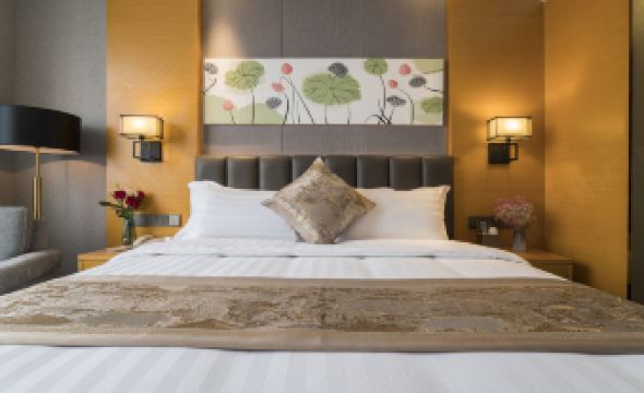 a large bed with a wooden headboard and white linens is shown in a hotel room at Orient Hotel