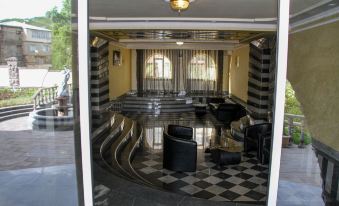 a large , open room with a checkered floor and black and white checkered walls features several chairs and a bar at Grand House hotel & zipline
