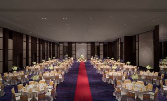 a large banquet hall is set up with tables , chairs , and a red carpet leading to the entrance at Avani Sepang Goldcoast Resort