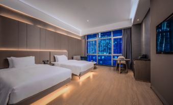 This room features double beds and large windows with a view of the city at night at Shenzhen Hyde Hotel
