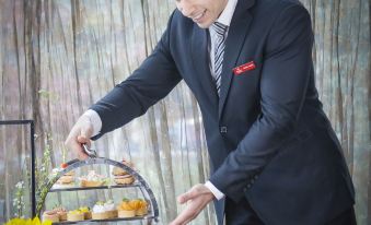 A man stands in front of a table with food and drinks beside him at Best Western Premier Ocean Hotel