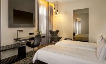 a modern hotel room with a white bed , black chair , and desk , along with other furniture and decorations at Park Plaza Victoria Amsterdam