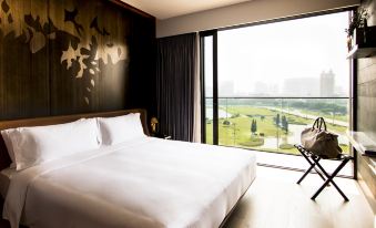 A bedroom with large windows and a balcony that overlooks the city, featuring an unmade bed at YOHO Hollywood Roosevelt Hotel
