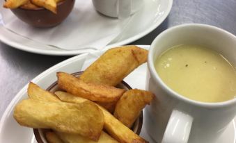 a dining table with two bowls of food , one filled with fries and the other with a bowl of soup at The Farm Burscough