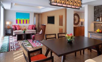 a dining room with a wooden table and chairs , a couch , and a colorful rug at Hyatt Regency Kuantan Resort