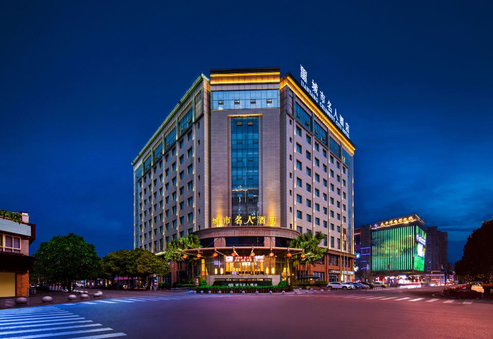 At night, the hotel building is illuminated by neon lights in the front at Celebrity City Hotel