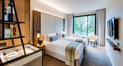 a large bedroom with two beds , one on the left and one on the right side of the room at Oval Hotel at Adelaide Oval, an EVT hotel