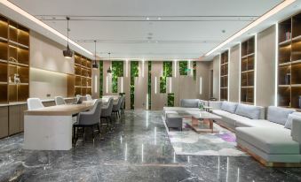 A modern living room with large windows and floor-to-ceiling glass features an L-shaped design at Lavande Hotel (Kunming Xishan Wanda Plaza Railway Station)