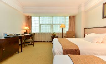 A bedroom with two double beds, large windows, and a table in the center for two people at Shanghai Baoan Hotel