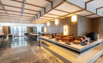 A spacious room with tables and chairs located in the center, adjacent to an open kitchen at Atour Hotel Shunde Happy Coast Foshan