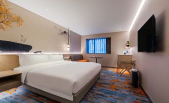 A spacious, contemporary bedroom on the top floor featuring a double bed and a generous sitting area in the center at Sunworld Beijing Wangfujing Hotel (The Forbidden City)