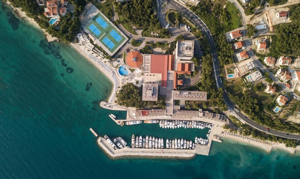 aerial view of a marina with multiple boats docked , including sailboats and yachts , near the water 's edge at Le Méridien Lav, Split