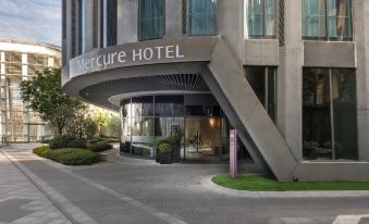 There is a building with an entrance to an office block on the ground floor and another entrance on the top floor at Mercure Hotel (Shanghai Hongqiao Railway Station)