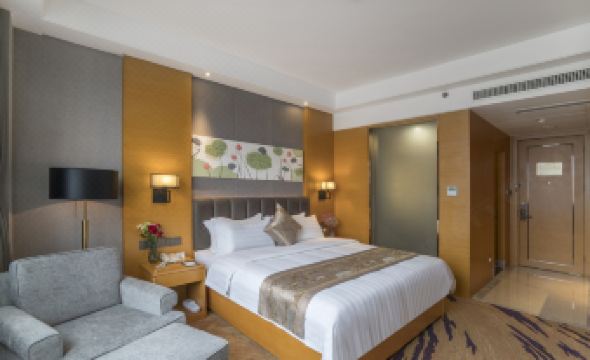 a hotel room with a king - sized bed , a couch , and a tv . also a dining table in the room at Orient Hotel