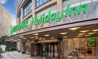 The entrance to a hotel is adorned with an illuminated sign above its glass door at Holiday Inn Shanghai Nanjing Road