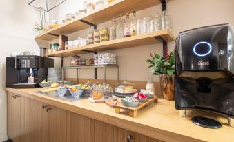 a dining area with a buffet table filled with various food items and utensils , including bowls , forks , knives , and spoons at Hotel Carlton