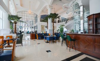 a spacious hotel lobby with a large reception desk , multiple chairs , and a potted plant at Mercure Urumqi South Lake