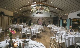 a large , elegant banquet hall with numerous dining tables and chairs set up for a wedding reception at Hotel Doolin