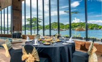 a dining room with a round table surrounded by chairs , all set for a formal dinner at Meruorah Komodo Labuan Bajo