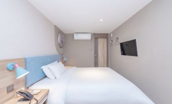 bedroom with a single bed, a spacious living room, and a fully equipped kitchenette at Pebble Hotel (Shanghai New International Expo Center Longyang Road Metro Station)