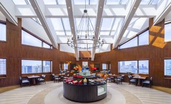 The restaurant in the center features large windows and floor-to-ceiling glass, creating an elegant dining experience at Radisson Collection Hyland Shanghai