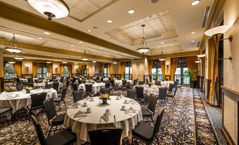 a large , well - lit banquet hall with numerous dining tables and chairs set up for a formal event at Hotel Grand Pacific