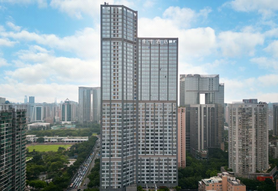 On one side, there is a large building with many windows surrounded by tall skyscrapers at All Seasons Hotel (Guangzhou Tianhe Sports Center Branch)