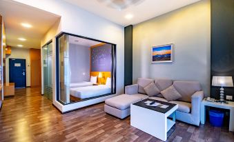 a modern living room with hardwood floors , a couch , and a tv . also a bed in the room at Nova Highlands Hotel