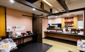 a dining area with a buffet table filled with various food items , including bowls , cups , and utensils at Hotel Wing International Miyakonojo