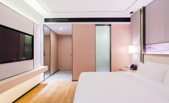 A contemporary bedroom features white walls and spacious sliding doors that open to another area at Ousika International Hotel (Dongguan Gaobu Tongfu)