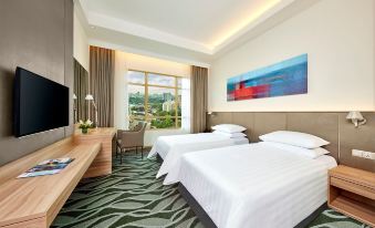 a hotel room with two beds , a tv , and a window overlooking a green landscape at Sunway Lagoon Hotel , Formerly Sunway Clio Hotel
